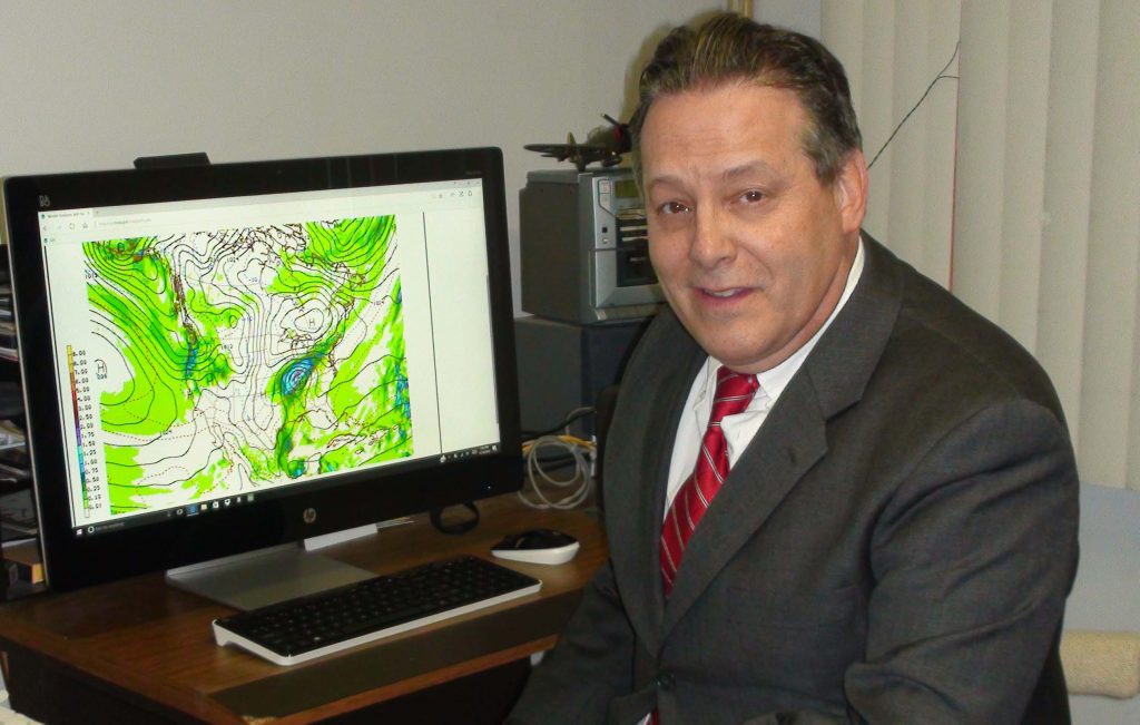 Person in office with meteorological data screen